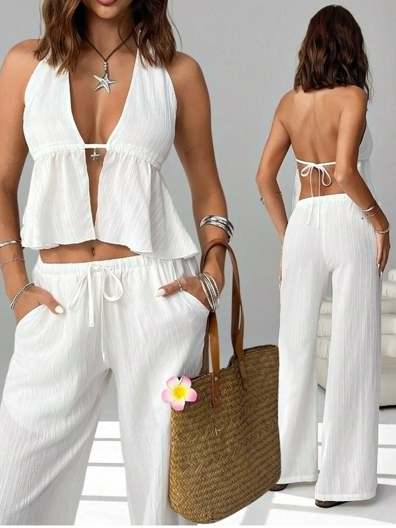 Woman in a white halter top and wide-leg pants set, holding straw tote bag, with boho jewelry.