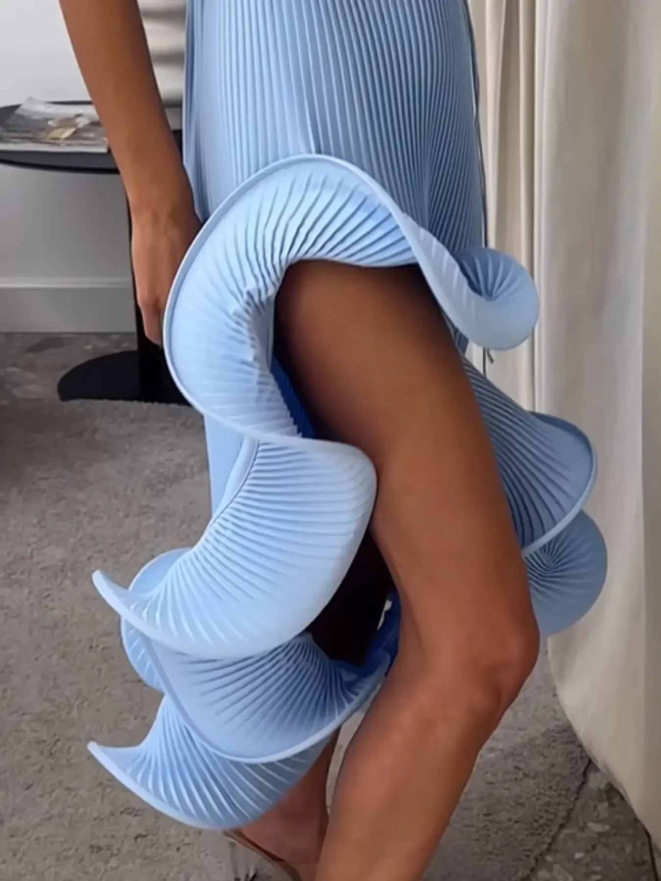 Light blue pleated ruffle skirt with high slit, modern women’s fashion outfit