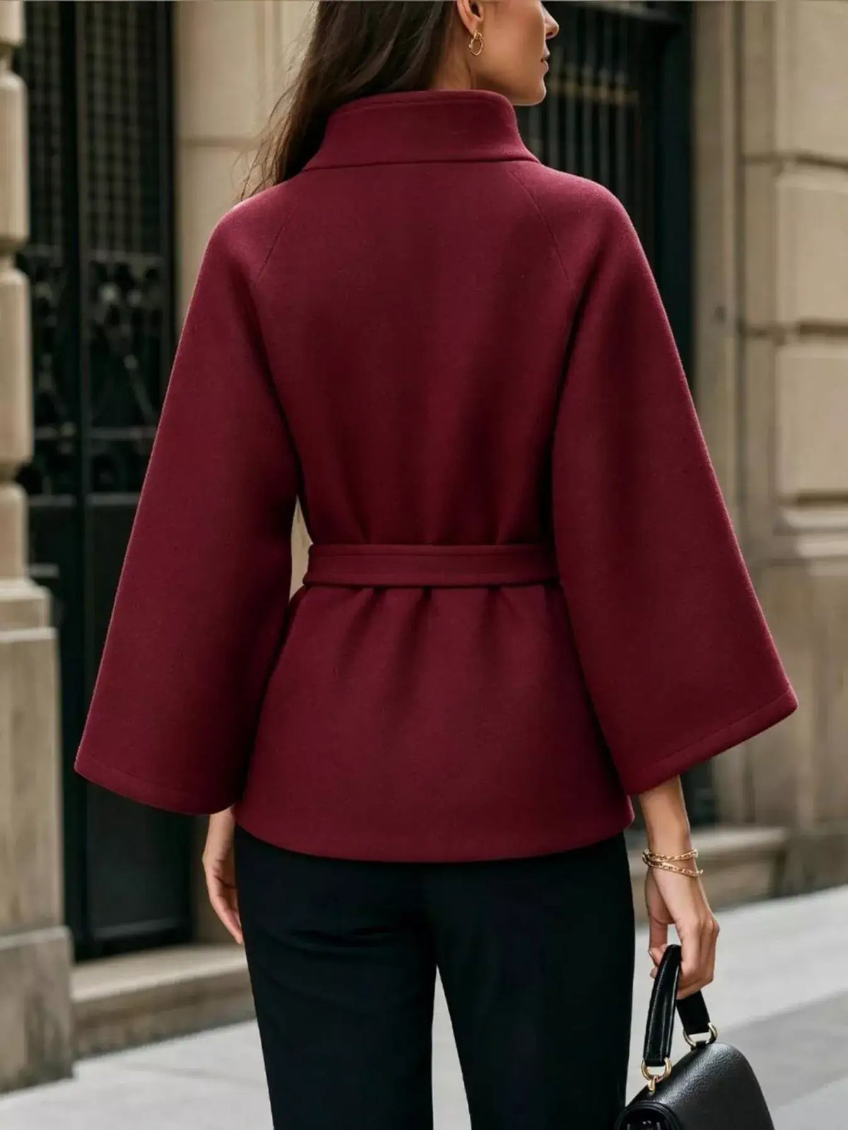Back view of a burgundy Evie's Dreamland belted cape coat with wide sleeves and a high collar.
