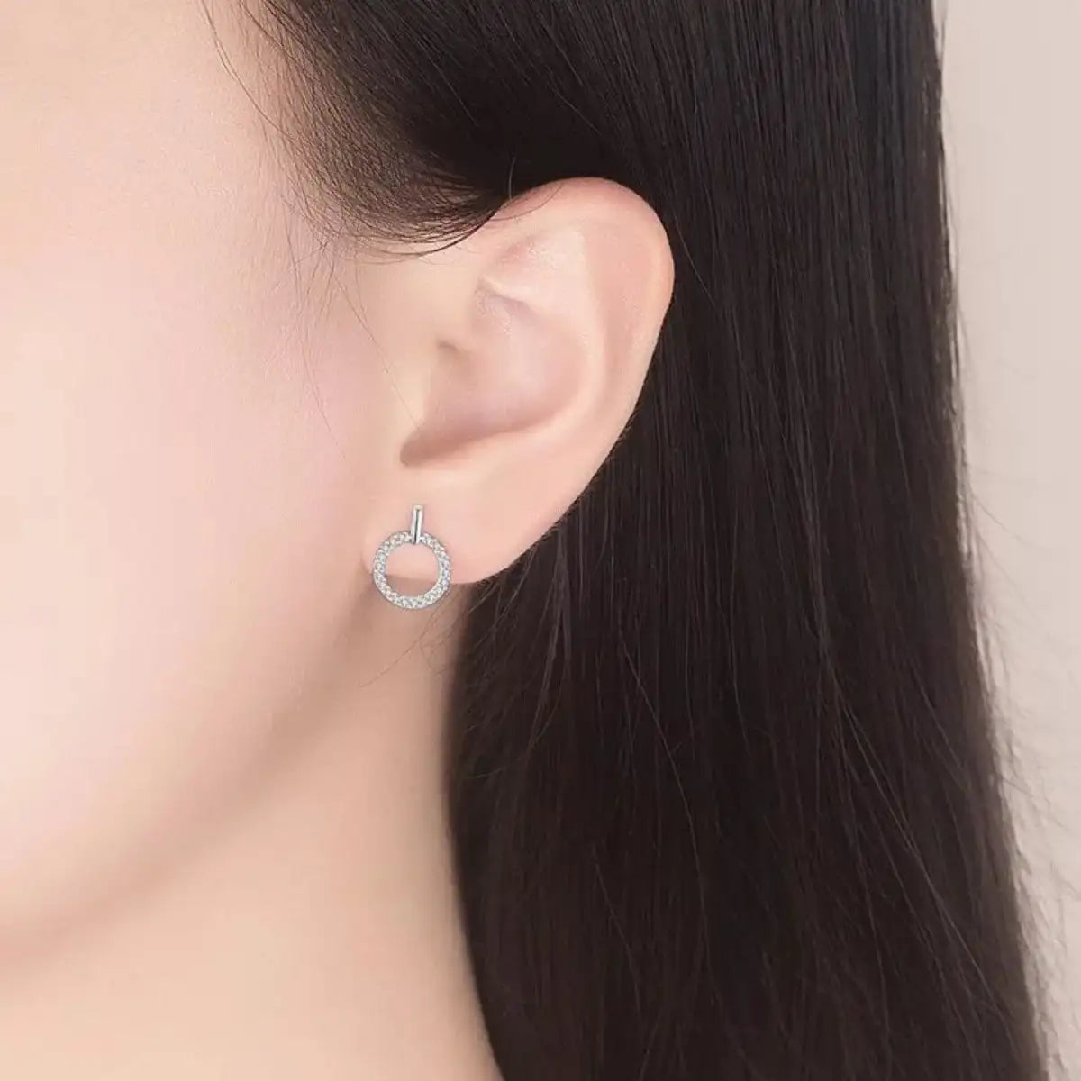 Close-up of a woman wearing Evie's Dreamland 925 sterling silver circle stud earrings with sparkling accents.