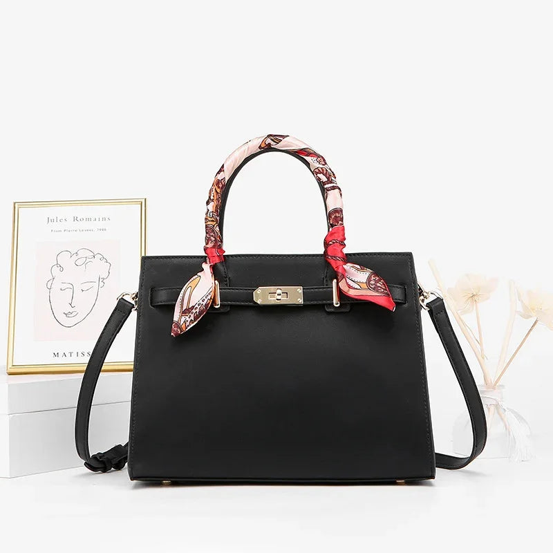 Black structured handbag with gold clasp, colorful scarf-wrapped handles, and detachable strap
