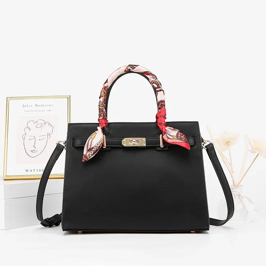 Black structured handbag with gold clasp, colorful scarf-wrapped handles, and detachable strap