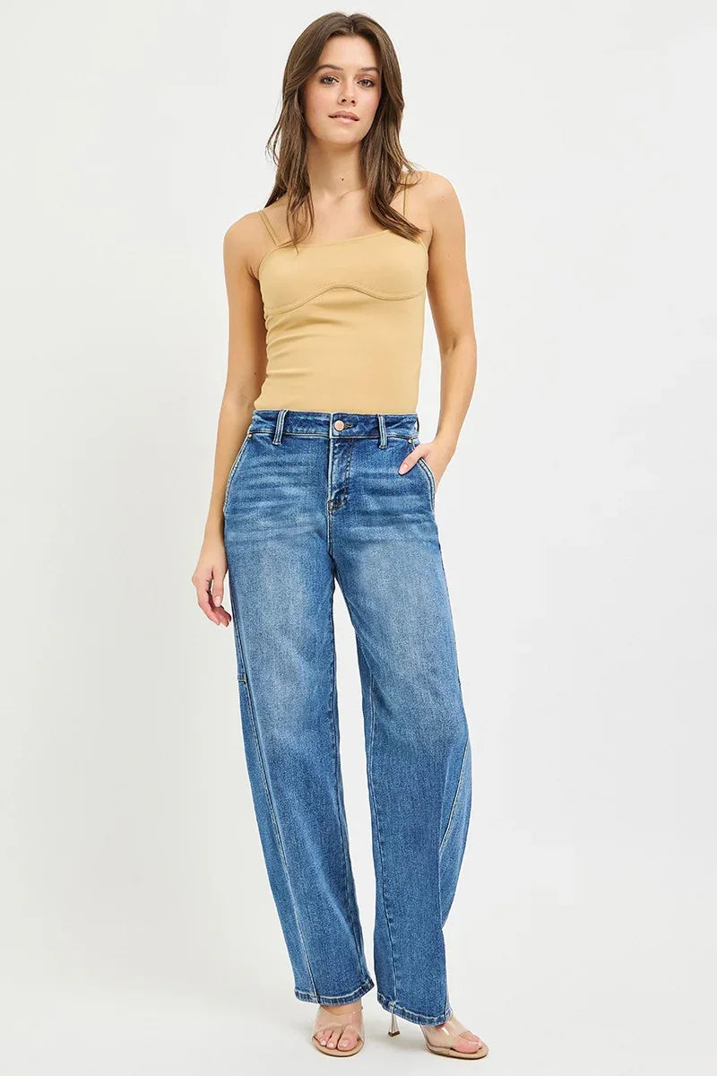 Woman in beige asymmetrical tank top and high-waisted wide-leg blue jeans
