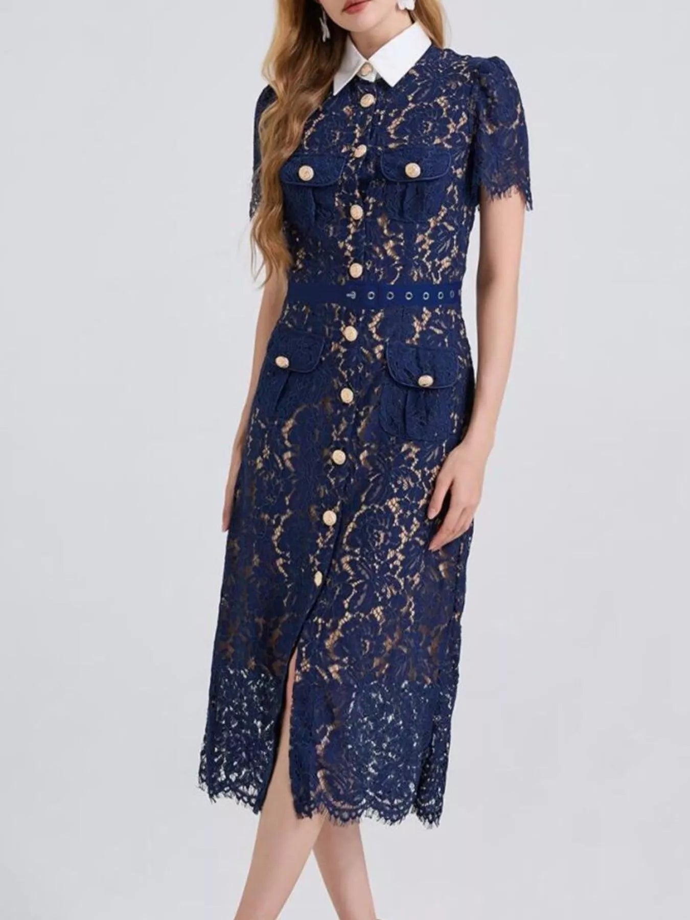 Woman wearing a navy blue lace midi dress with white collar and gold button details.