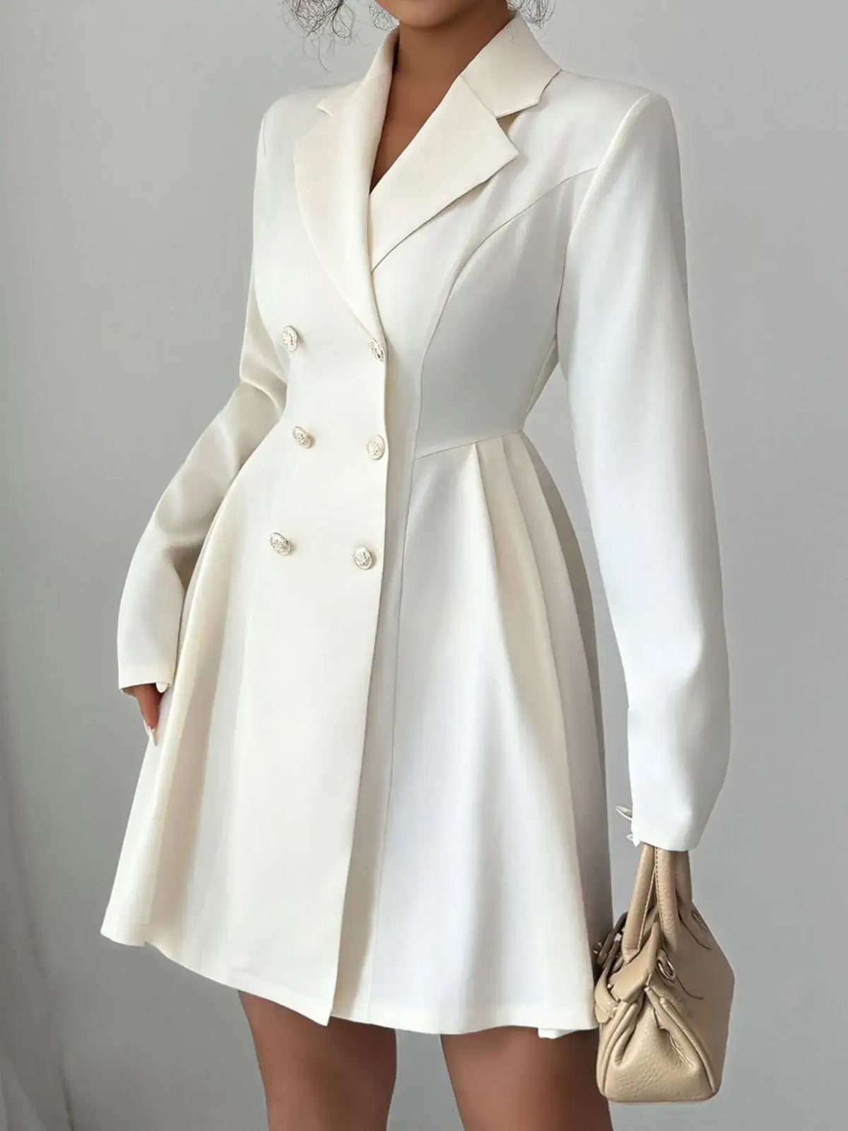 White double-breasted blazer dress by Evie's Dreamland with long sleeves and pleated skirt detail.