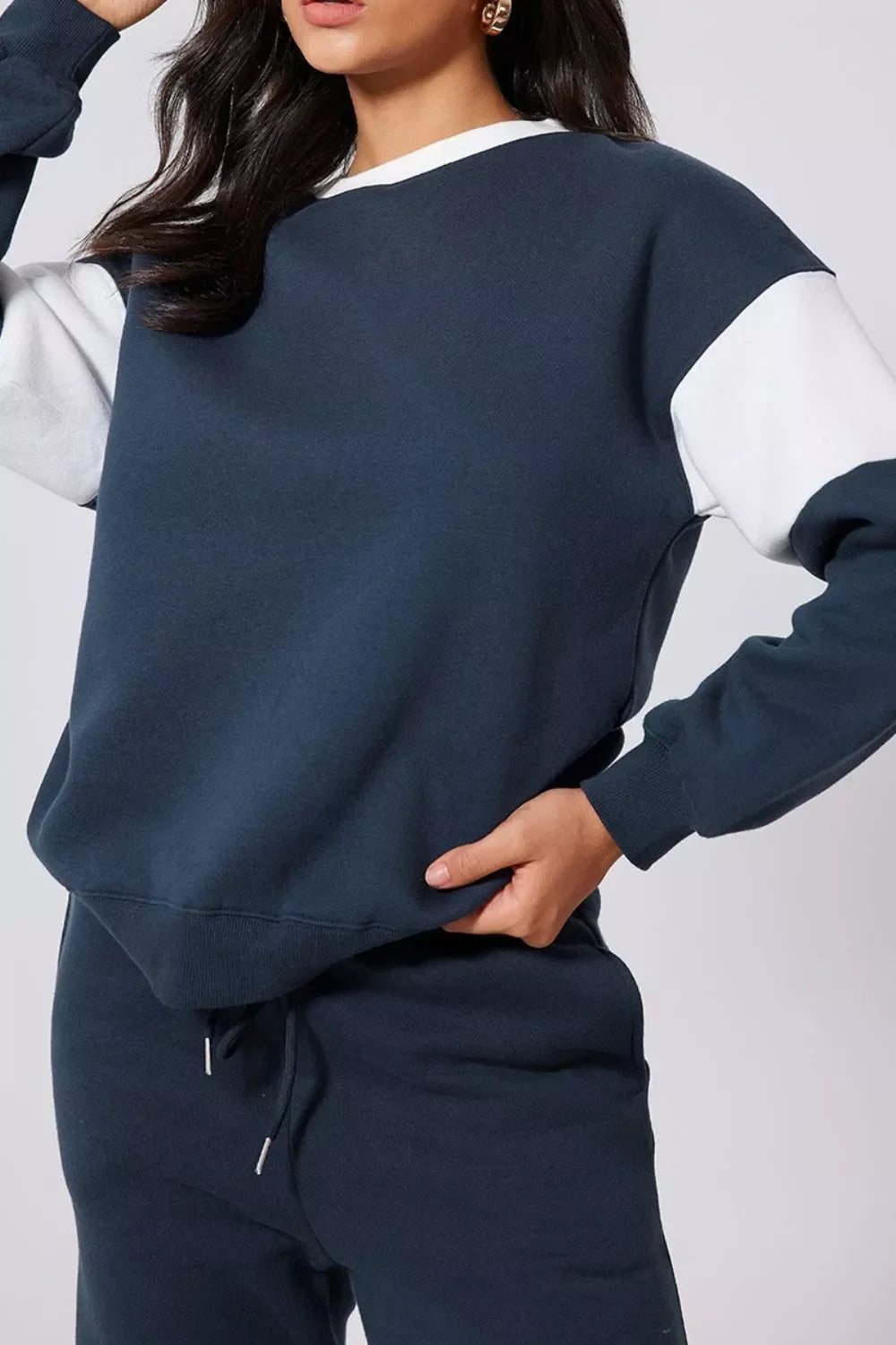 Woman wearing navy blue and white colorblock sweatshirt and navy joggers casual outfit