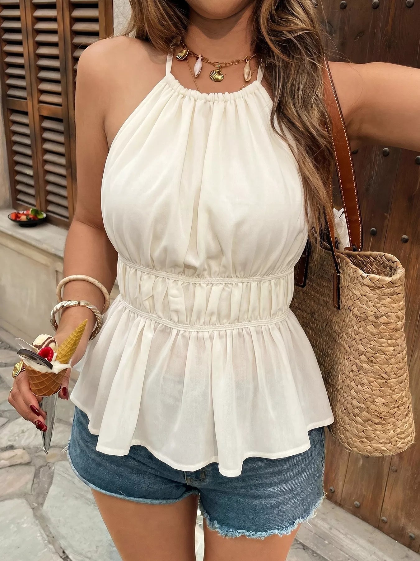 White halter neck peplum top with denim shorts, straw tote bag, and shell necklace for summer fashion