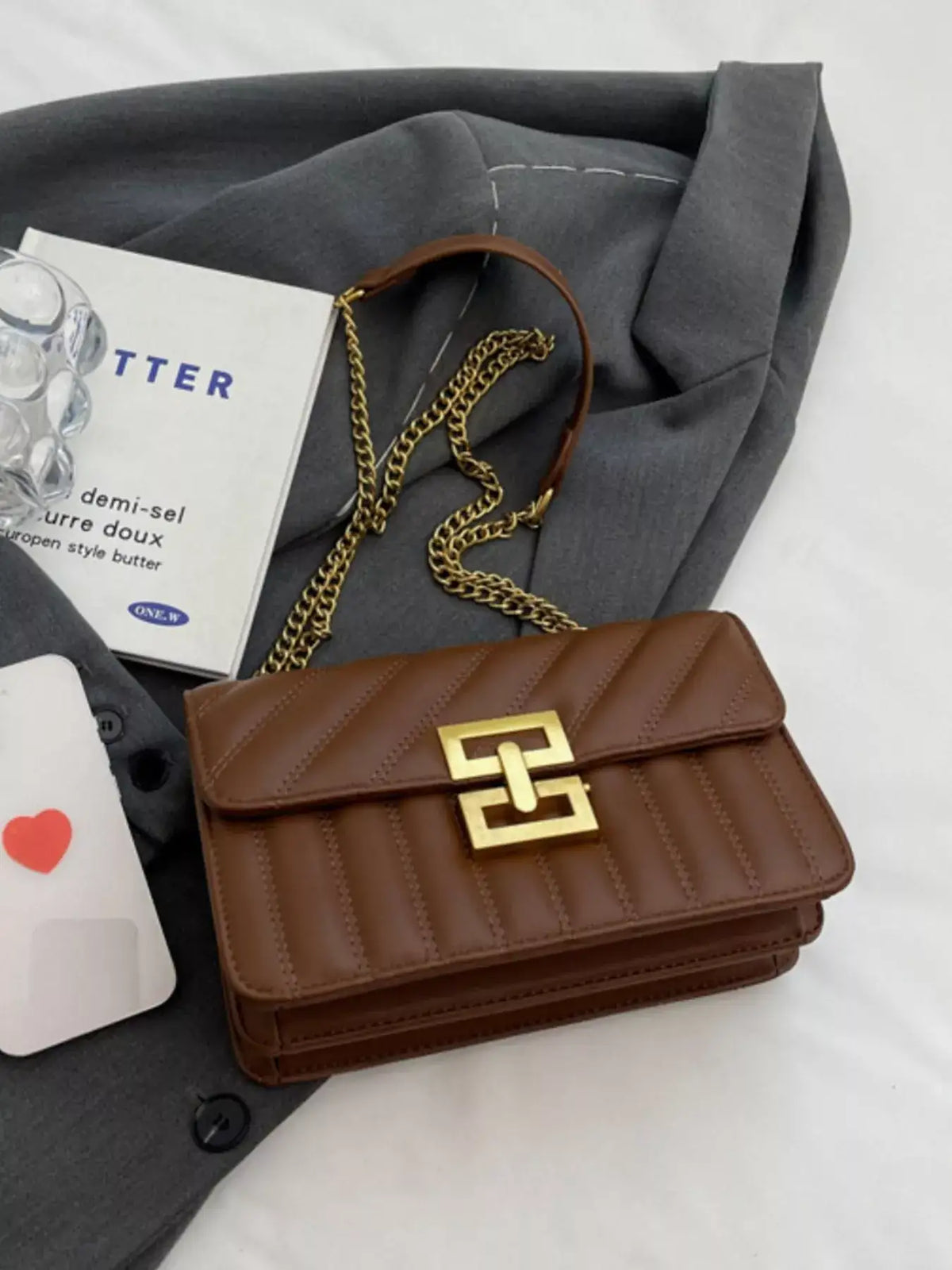 Brown quilted PU leather flap shoulder bag by Evie's Dreamland with gold chain strap and buckle.