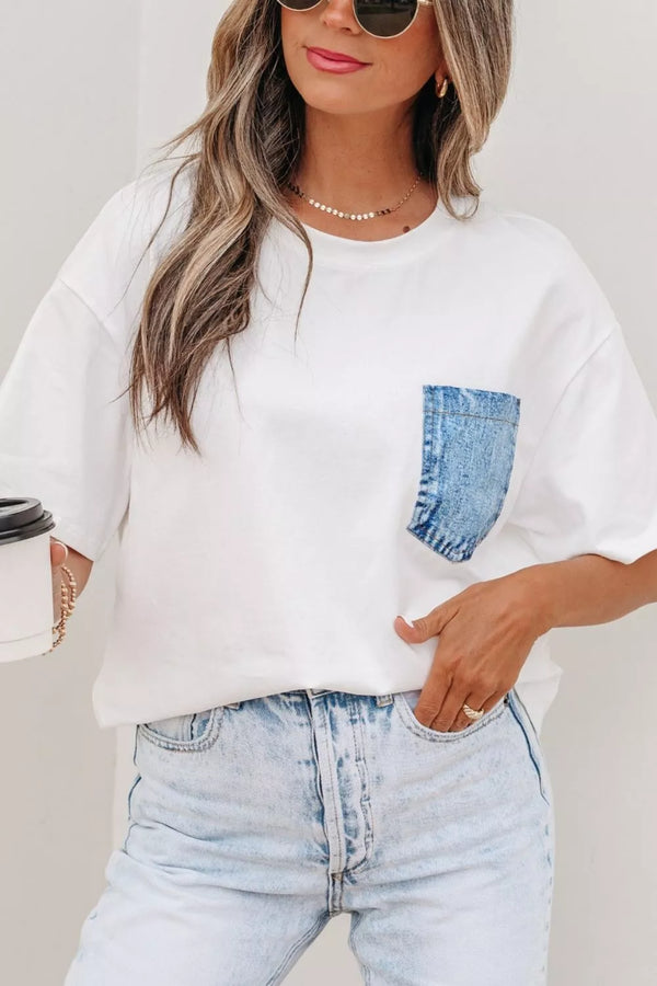 White oversized t-shirt with denim pocket, paired with light wash jeans and sunglasses for casual chic style