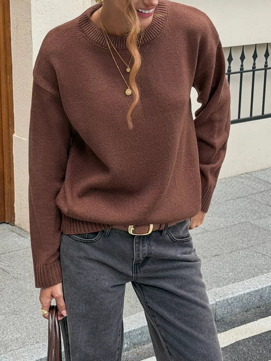 Woman wearing an Evie's Dreamland brown crew neck ribbed hem sweater paired with dark grey jeans.