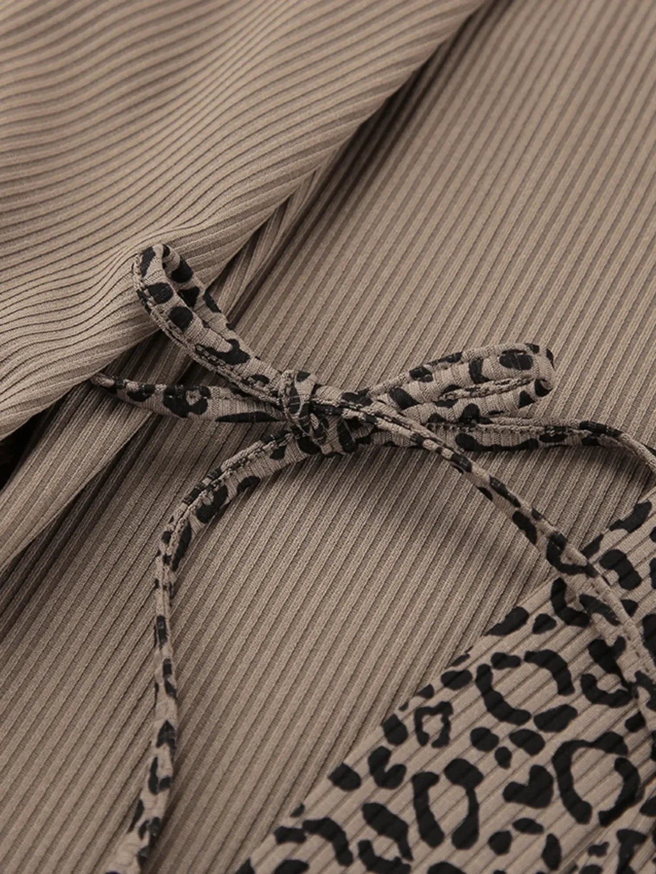 Beige ribbed fabric with leopard print tie bow detail on garment