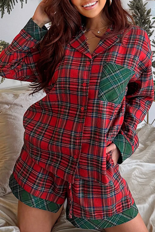 smiling woman wearing red and green plaid button-up pajama set with shorts in cozy bedroom