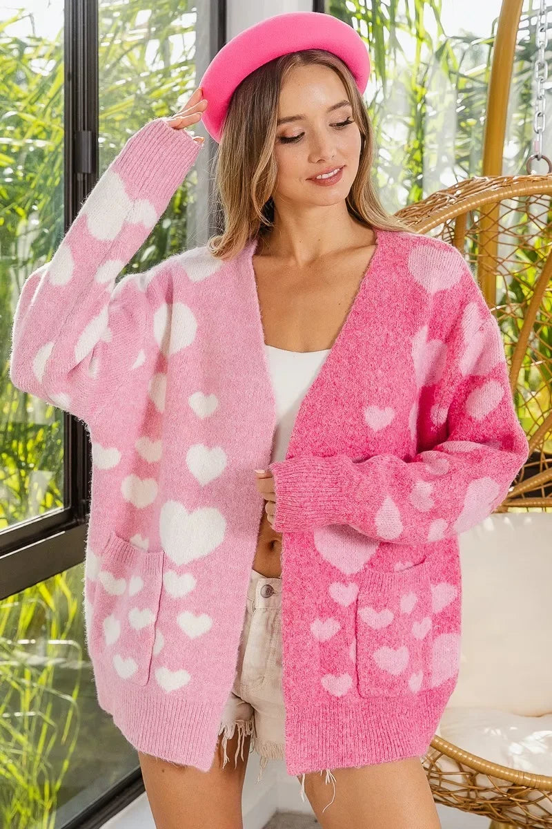 Woman wearing a pink and light pink heart-patterned oversized cardigan and pink beret indoors