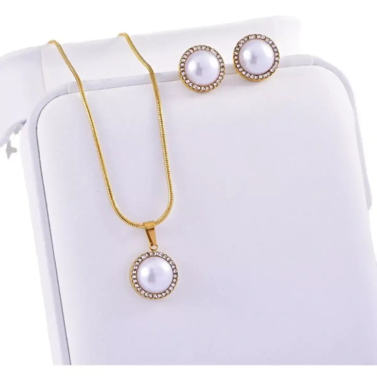 Evie's Dreamland 18K gold-plated pearl and rhinestone necklace and earring set on a white display box.