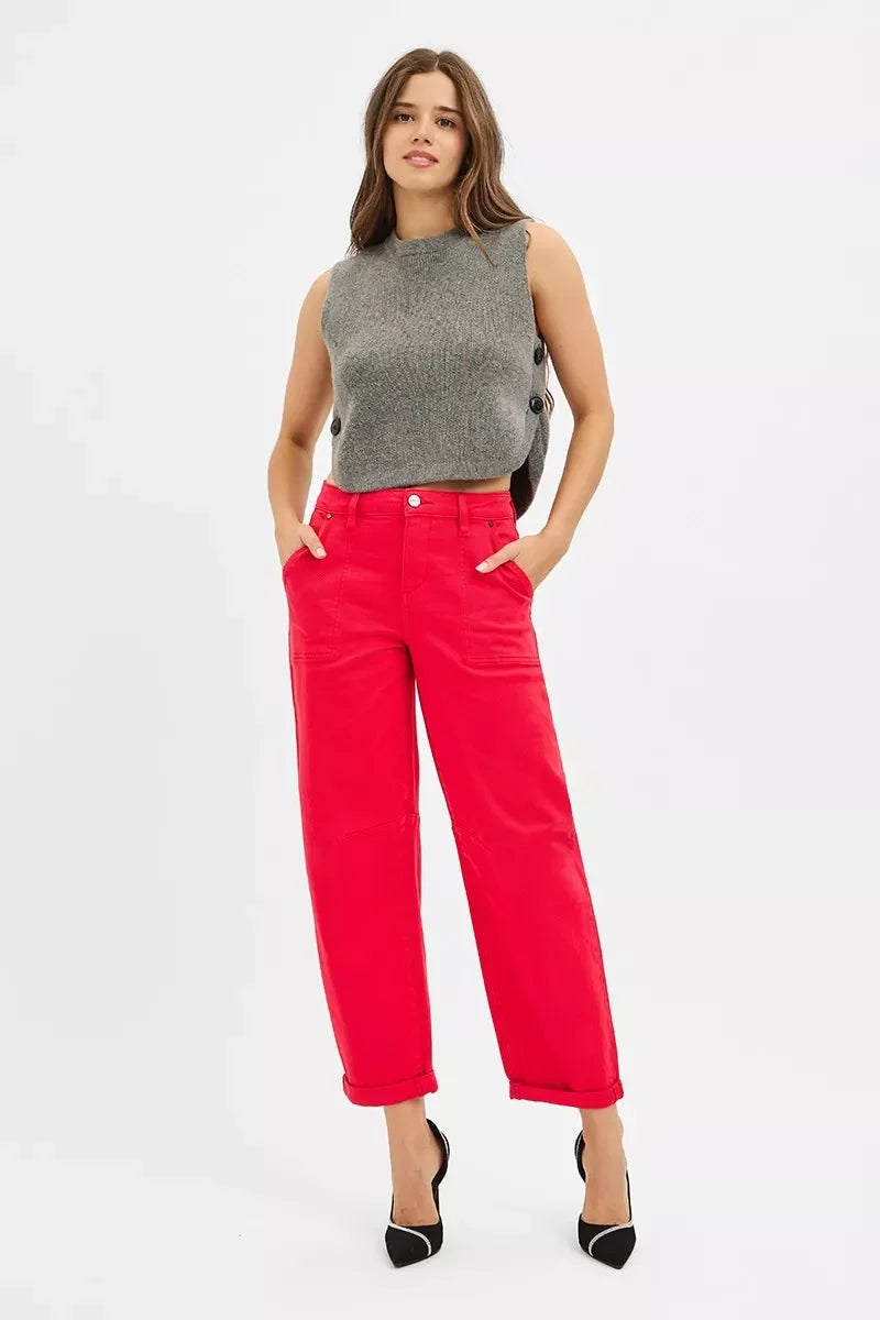 Woman wearing sleeveless gray knit top with side buttons and bright red wide-leg pants with black heels