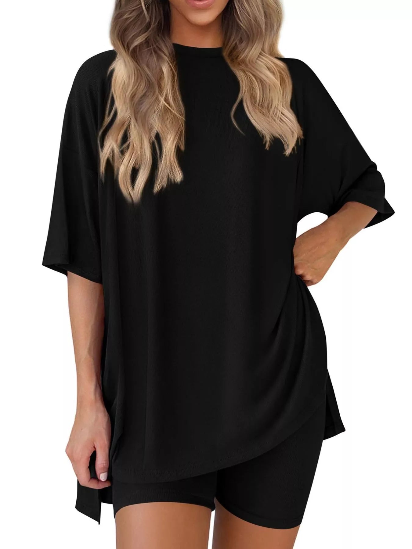 Woman wearing oversized black t-shirt and black biker shorts, casual loungewear outfit