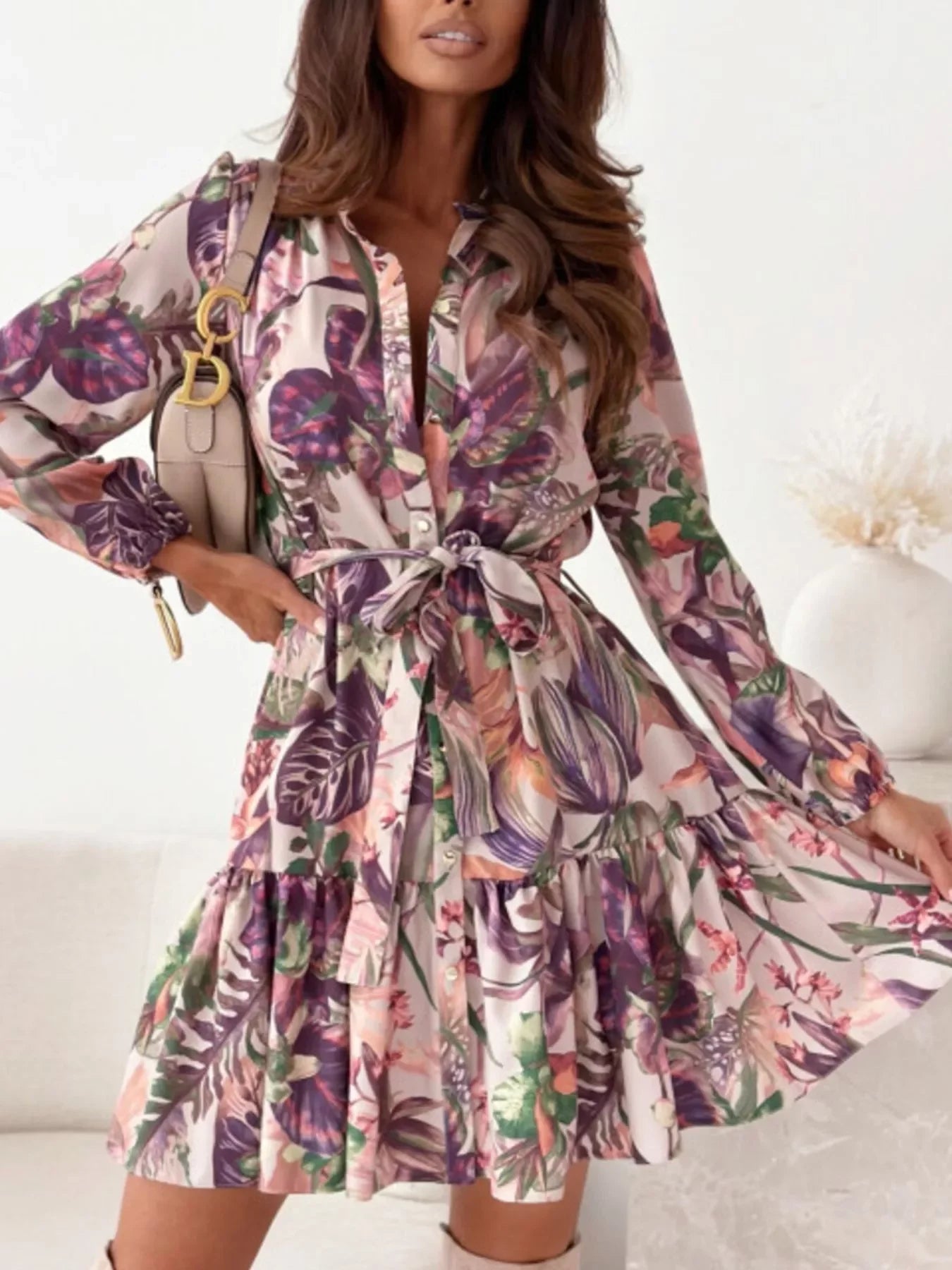 Woman wearing a floral print tie-waist mini dress with long sleeves