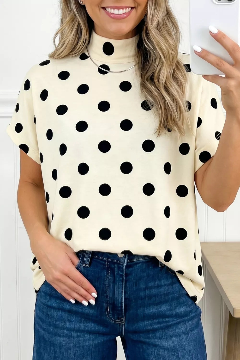Cream polka dot turtleneck top paired with blue jeans for casual chic style