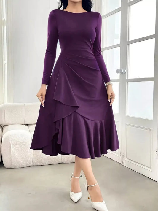Woman wearing a long-sleeve purple midi dress with ruffle details and white ankle-strap heels indoors