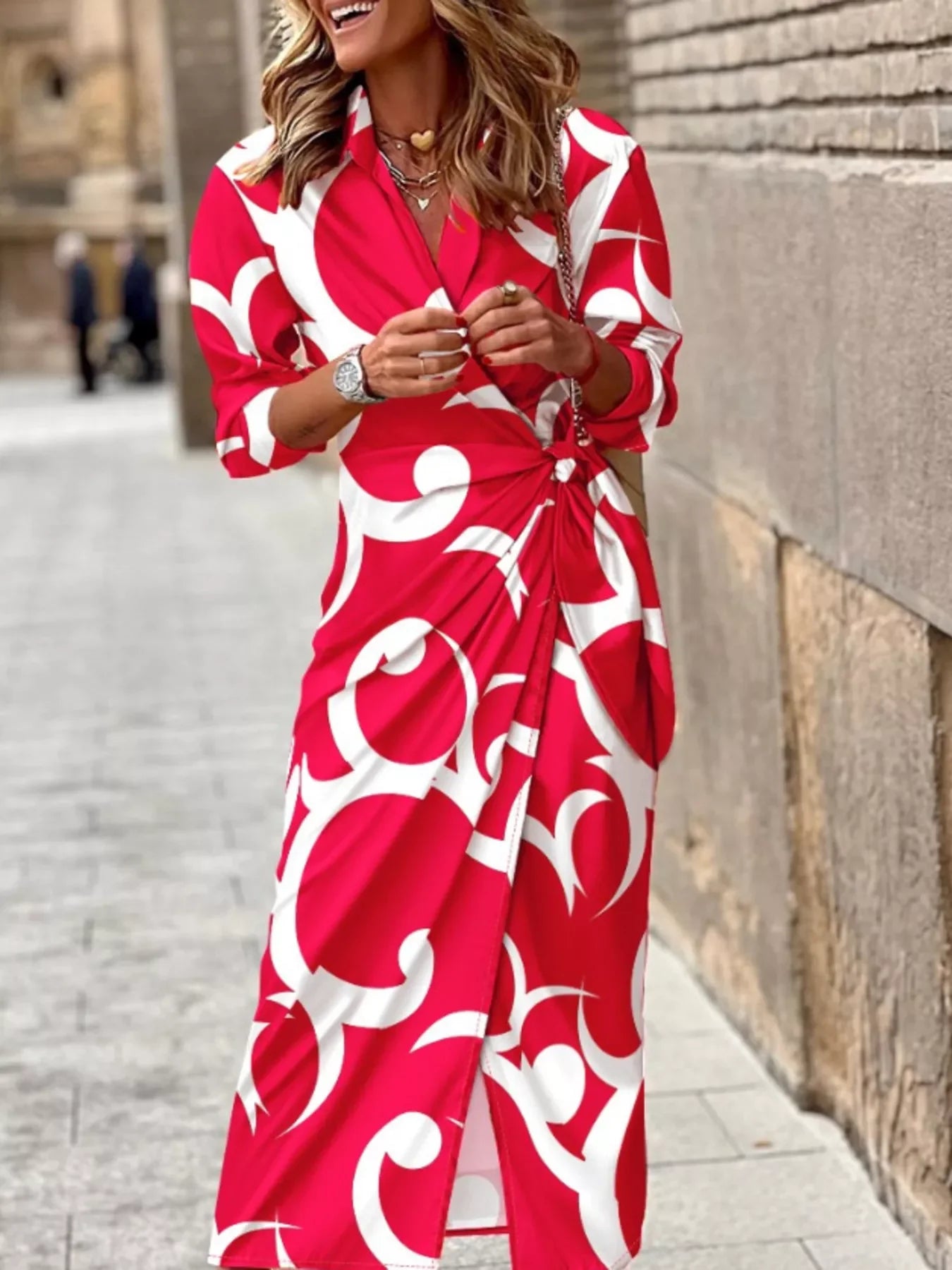 Woman wearing red and white abstract print wrap dress on city street