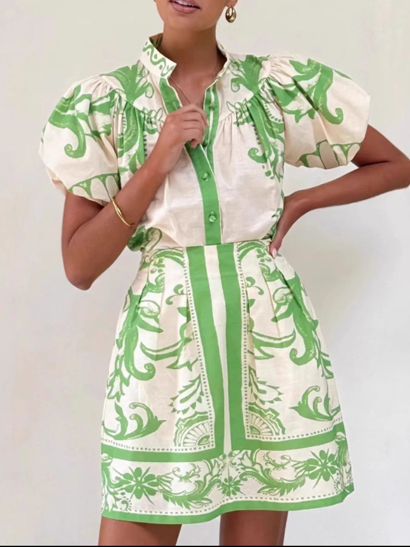 Woman wearing a green and white short-sleeve printed dress with puff sleeves and a collared neckline