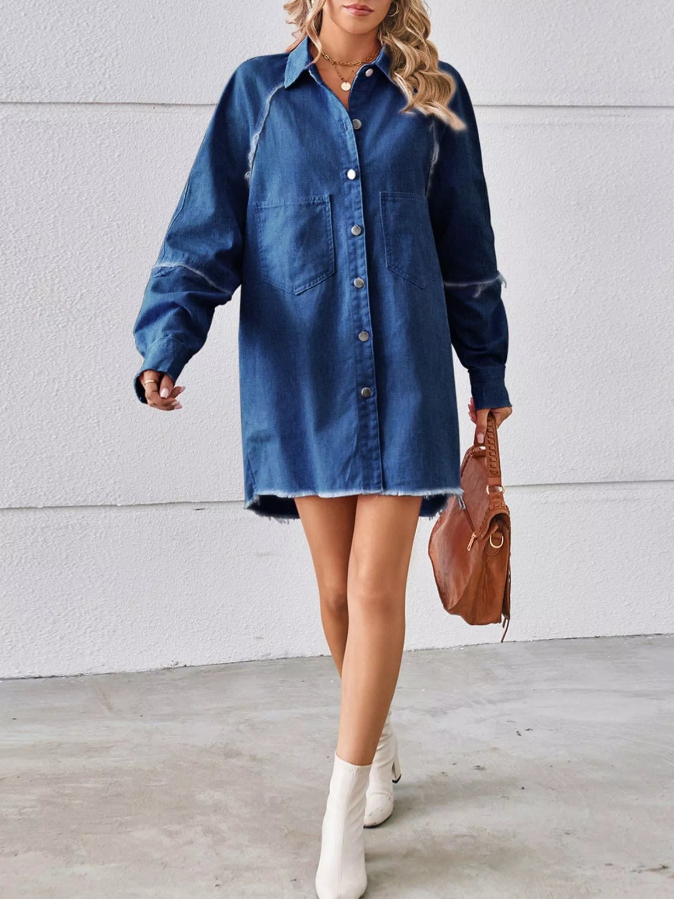 Woman wearing a denim shirt dress with white ankle boots and a brown handbag