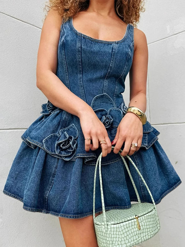 Woman wearing a blue denim mini dress with floral accents, holding a mint green handbag