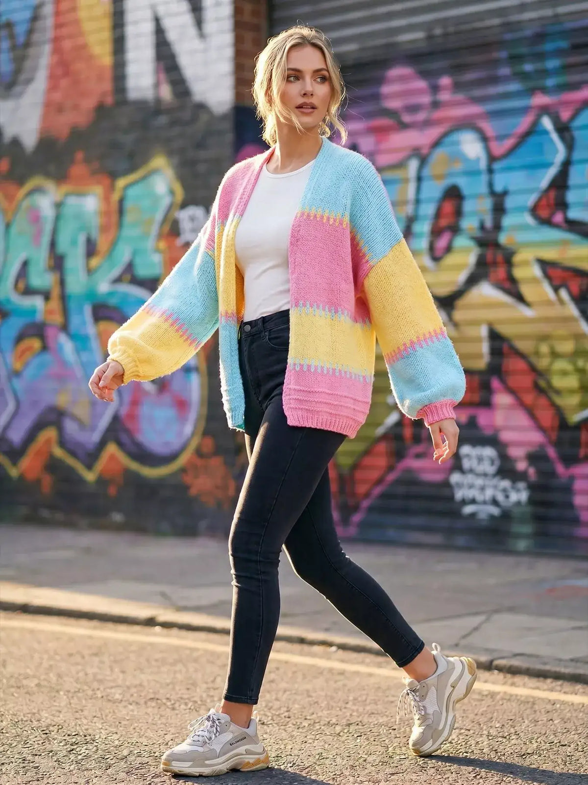 Woman wearing an Evie's Dreamland color-block V-neck cardigan with pastel stripes and black skinny jeans.