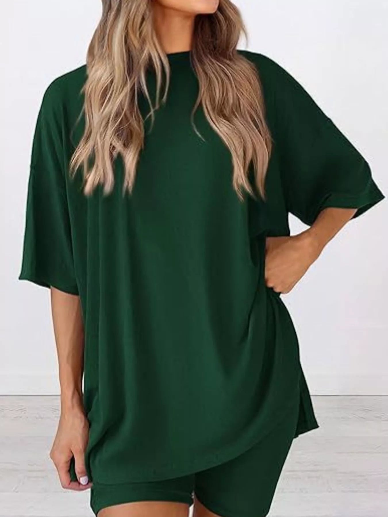 Woman wearing an oversized dark green T-shirt and matching shorts, casual loungewear set.