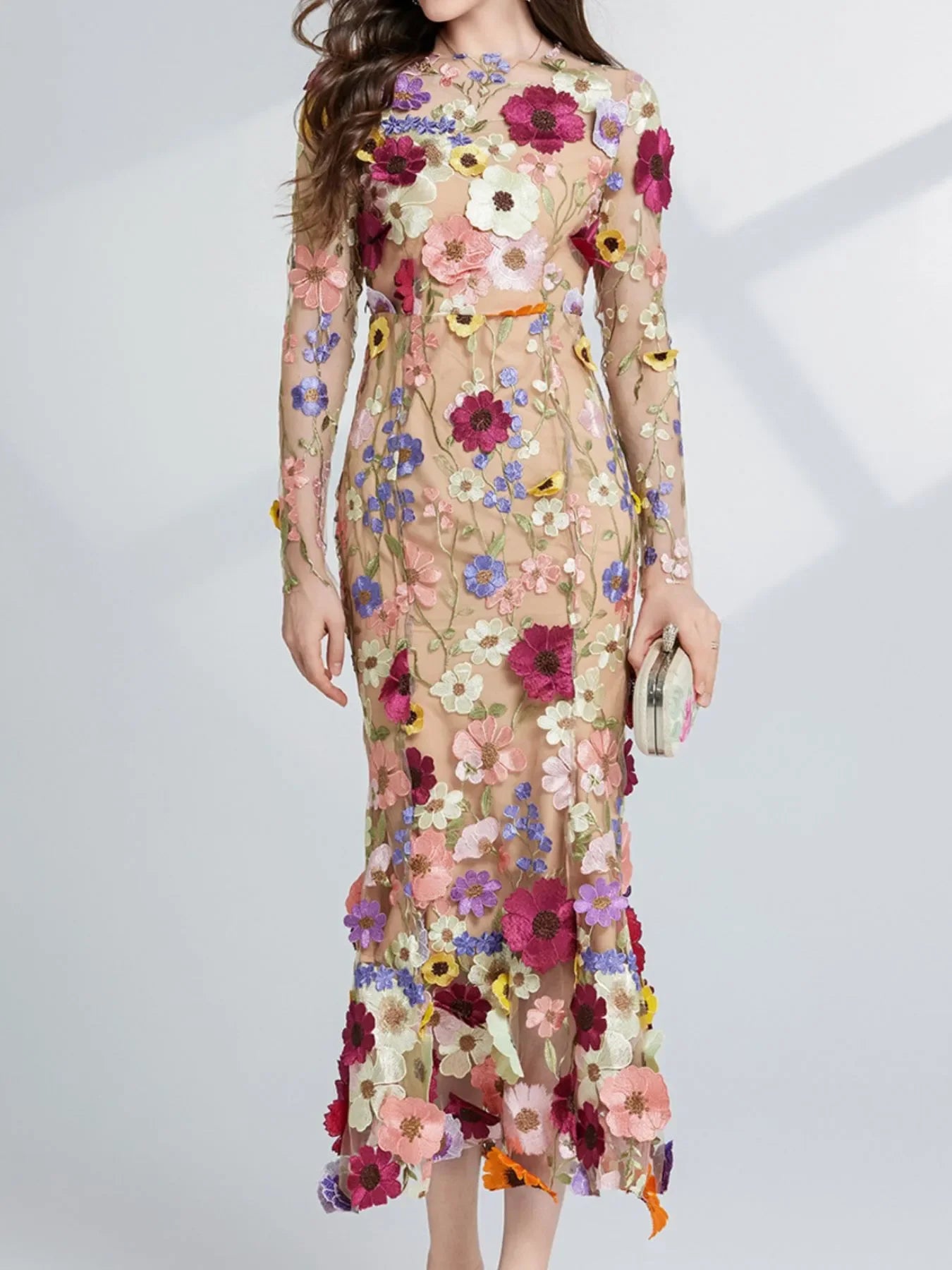 Woman in sheer nude floral embroidered long dress with colorful flower patterns