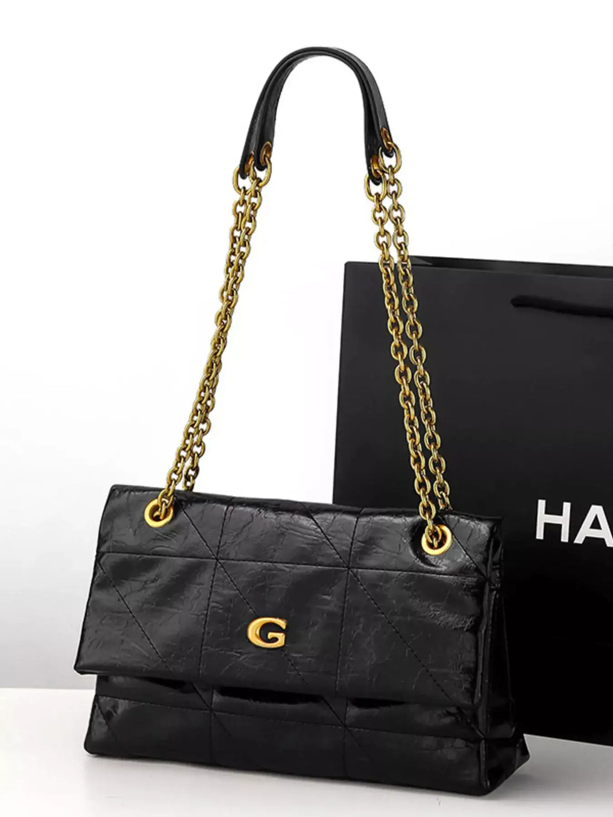 Black geometric quilted PU leather shoulder bag by Evie's Dreamland with gold chain strap.