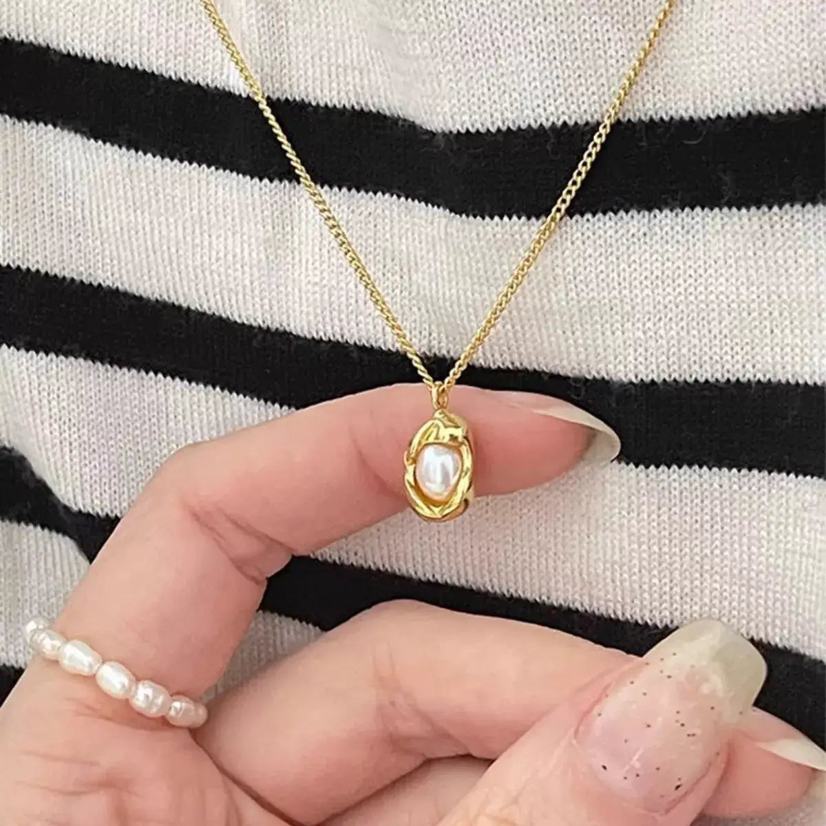 Evie's Dreamland gold-toned freshwater pearl necklace worn with a black and white striped top.