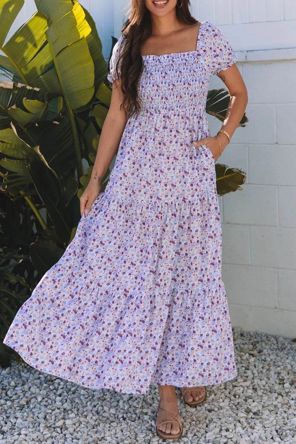 Woman wearing a floral maxi dress with smocked bodice and short sleeves outdoors