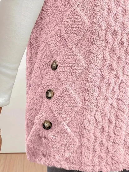 Close-up of pink textured fleece vest with three buttons over white sleeve top