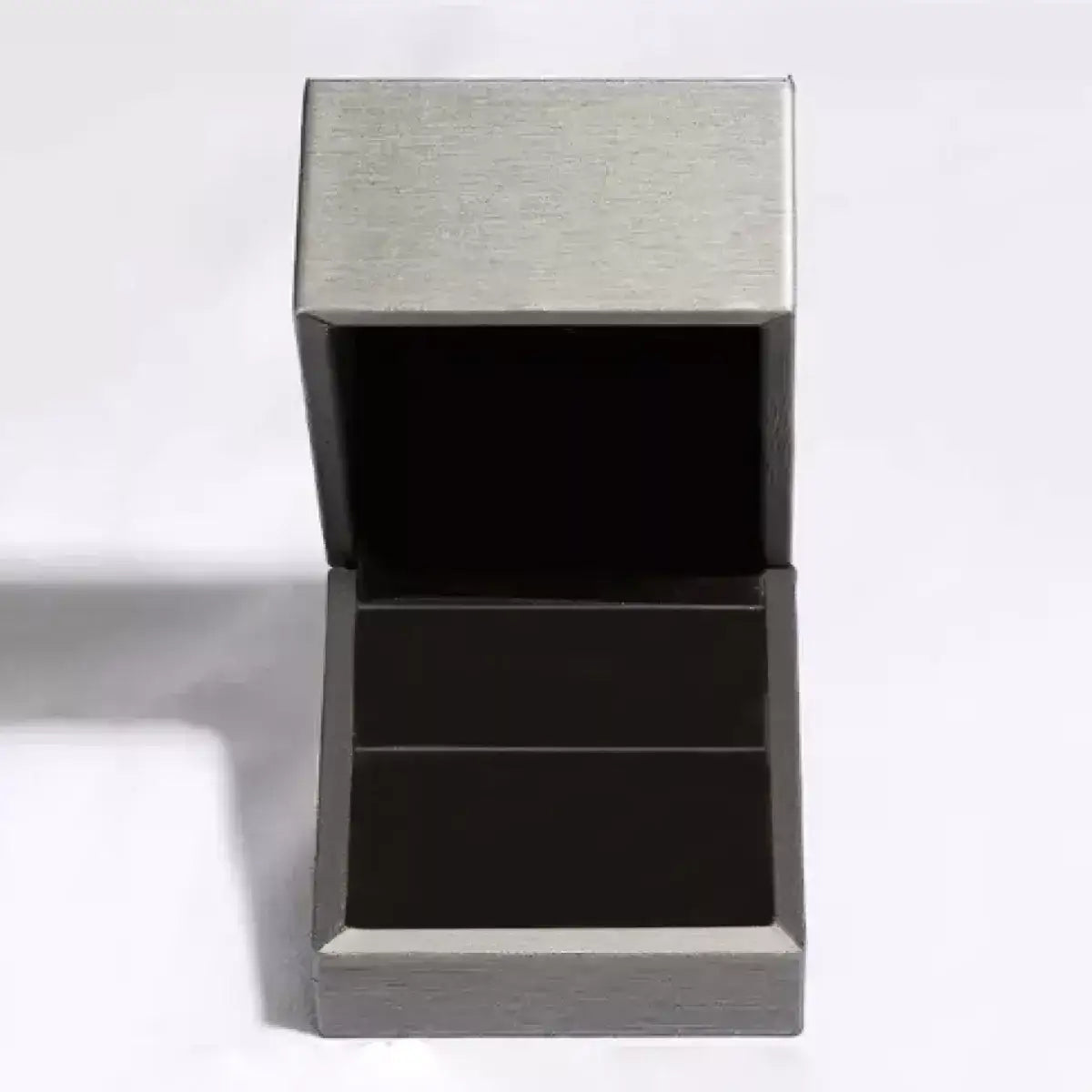 Open silver luxury jewelry gift box with a black velvet interior.