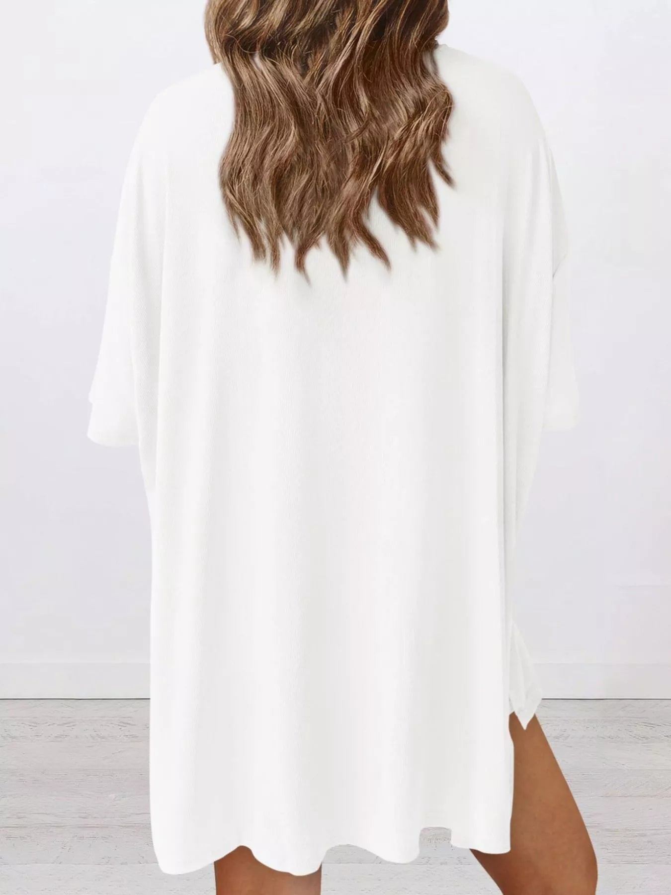 Woman wearing loose white oversized t-shirt dress, back view, casual outfit