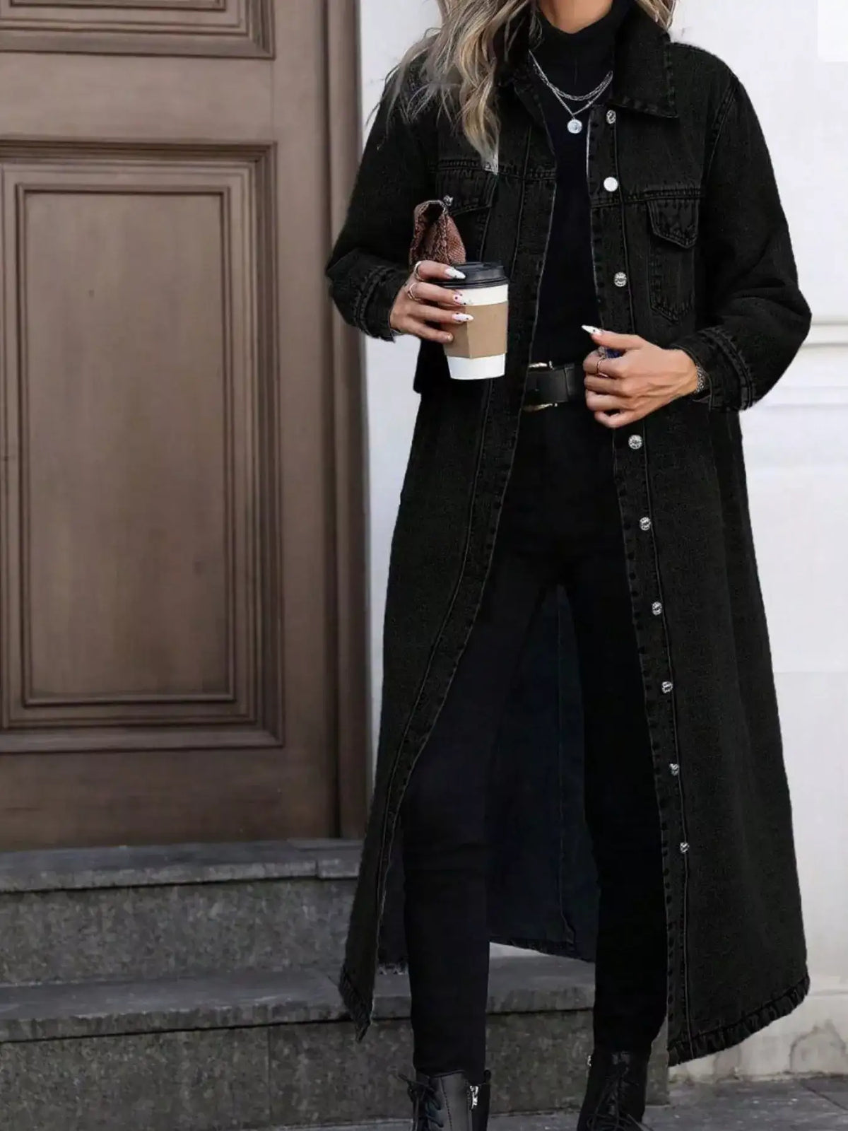 Woman wearing an Evie's Dreamland black longline denim jacket with button-front over a black turtleneck.