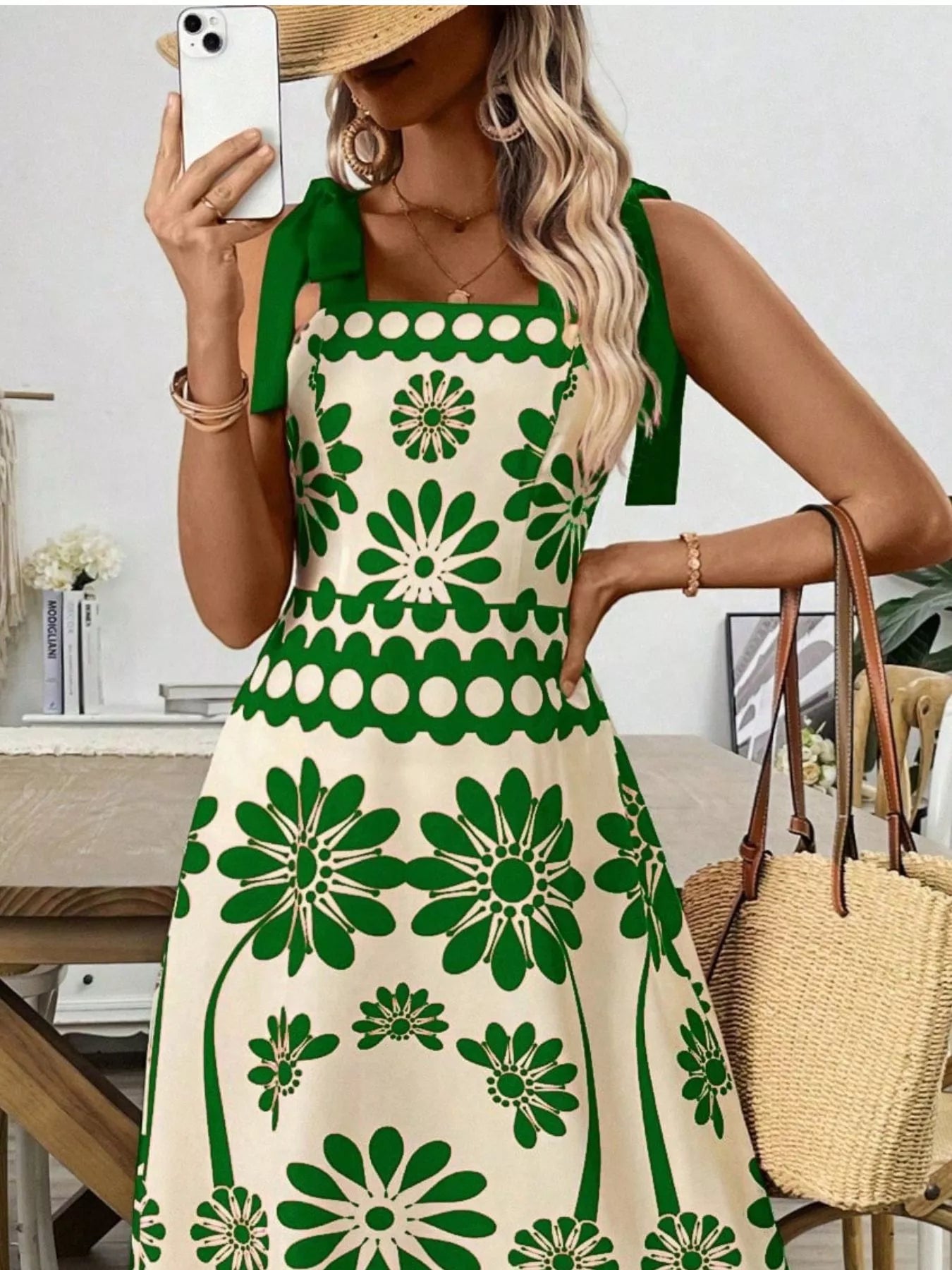 Green floral print dress with bow straps, styled with straw hat and woven bag for summer elegance.