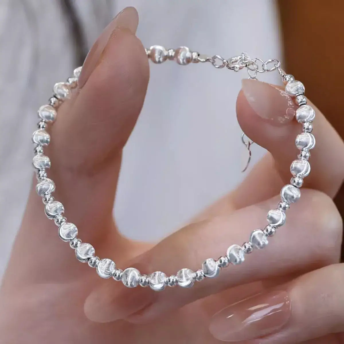 Trendsi 925 sterling silver beaded bracelet held in a hand, showcasing a polished, minimalist design.