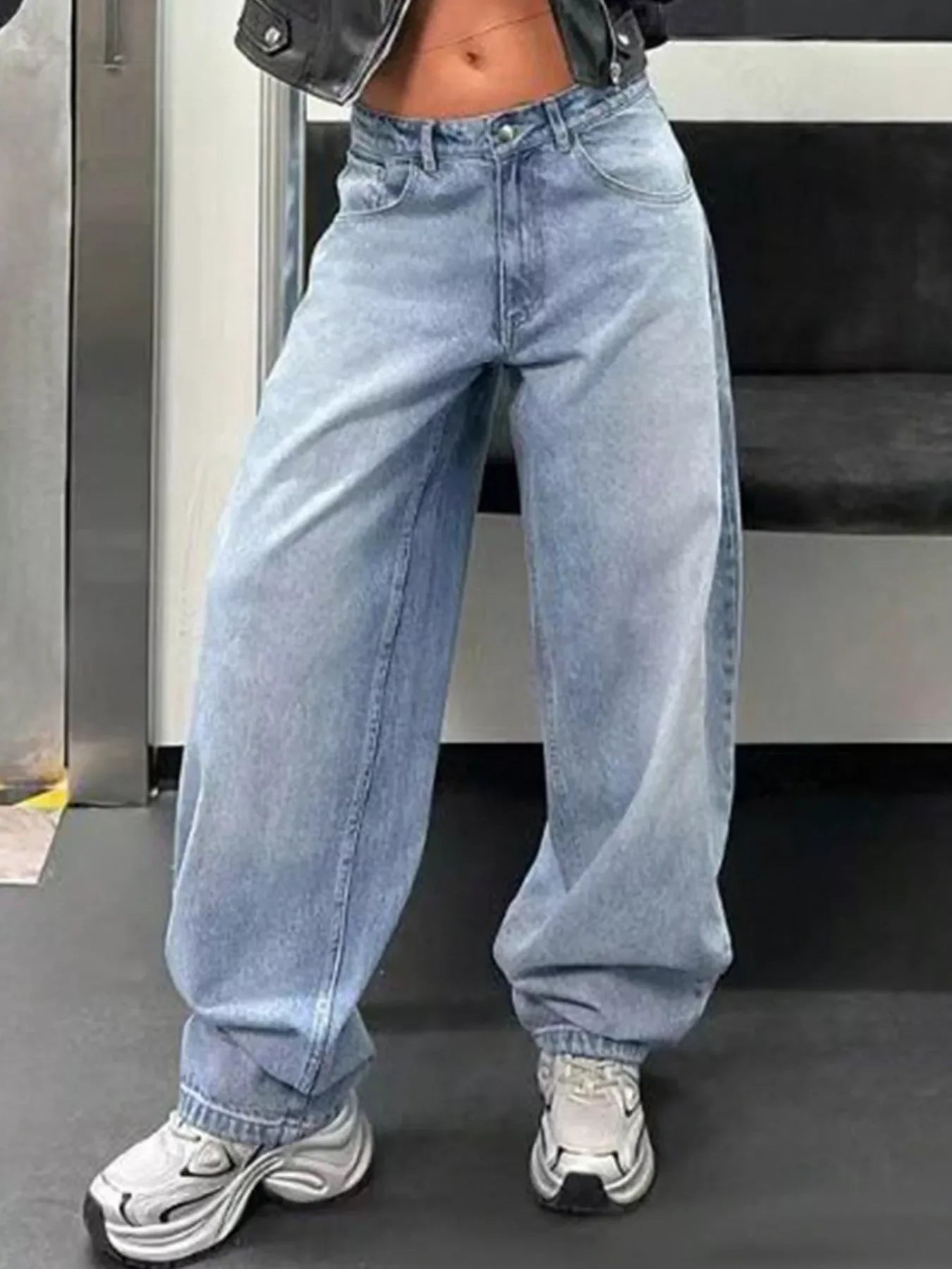 Woman wearing high-waisted wide-leg light wash jeans and chunky sneakers