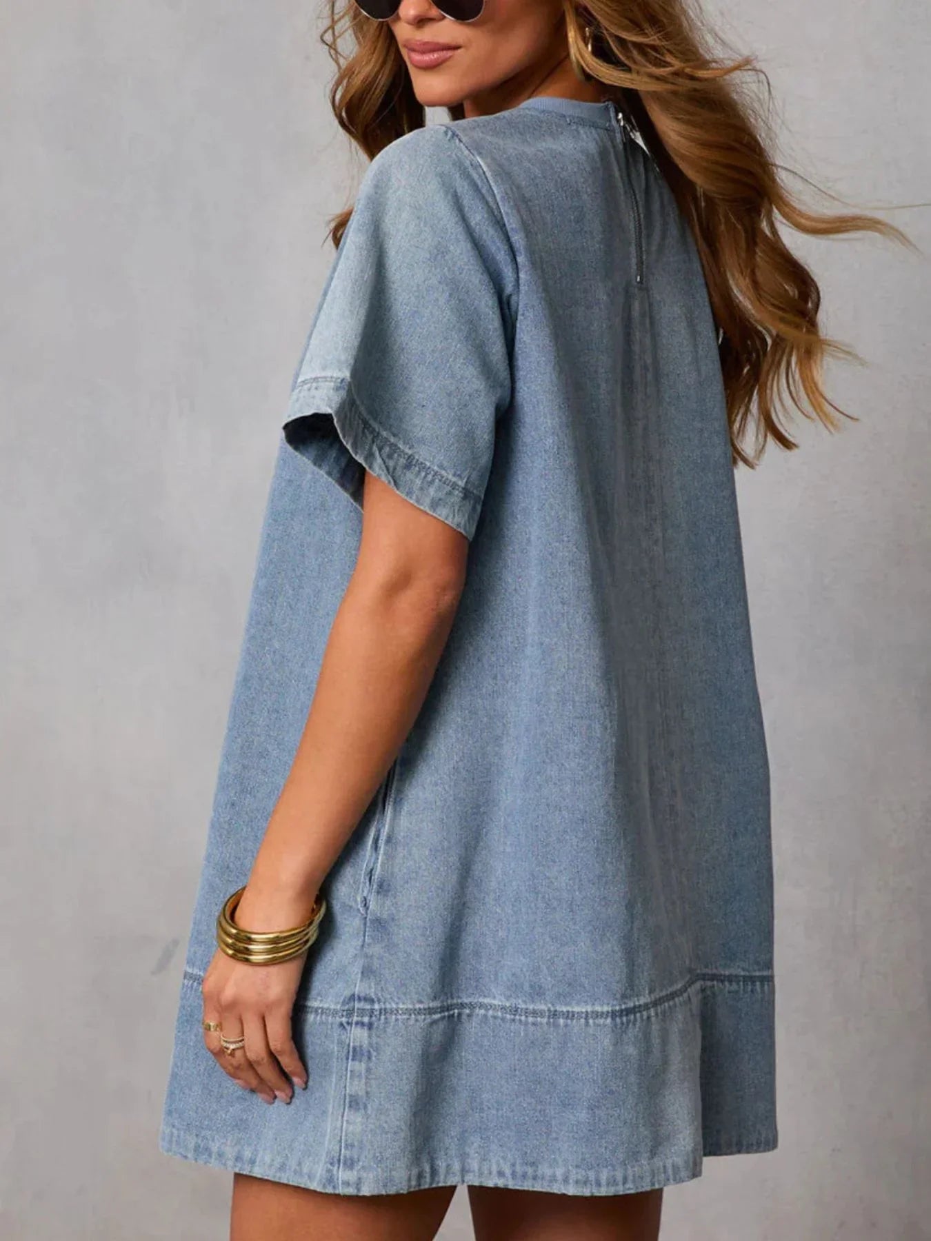 Woman wearing a short sleeve light denim dress and gold bangles, casual chic style