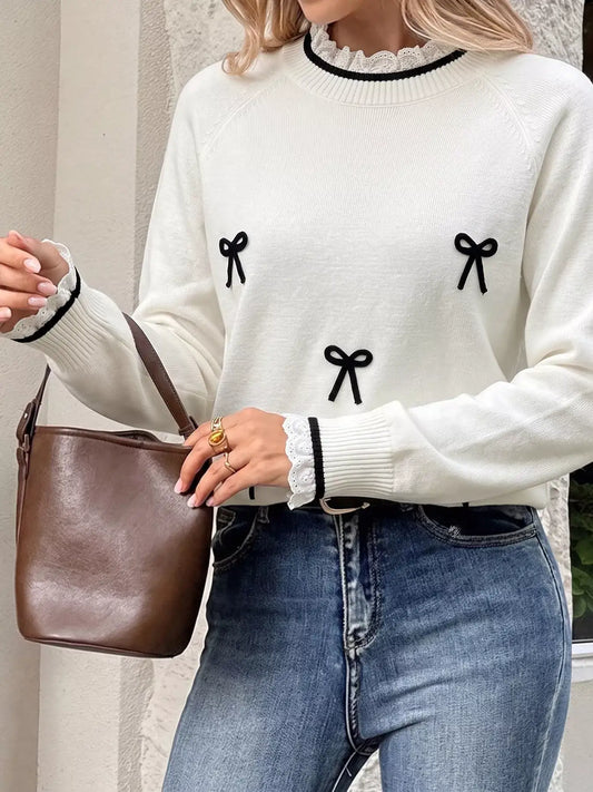Evie's Dreamland white bow-embellished sweater with lace trim neckline and cuffs paired with blue jeans.