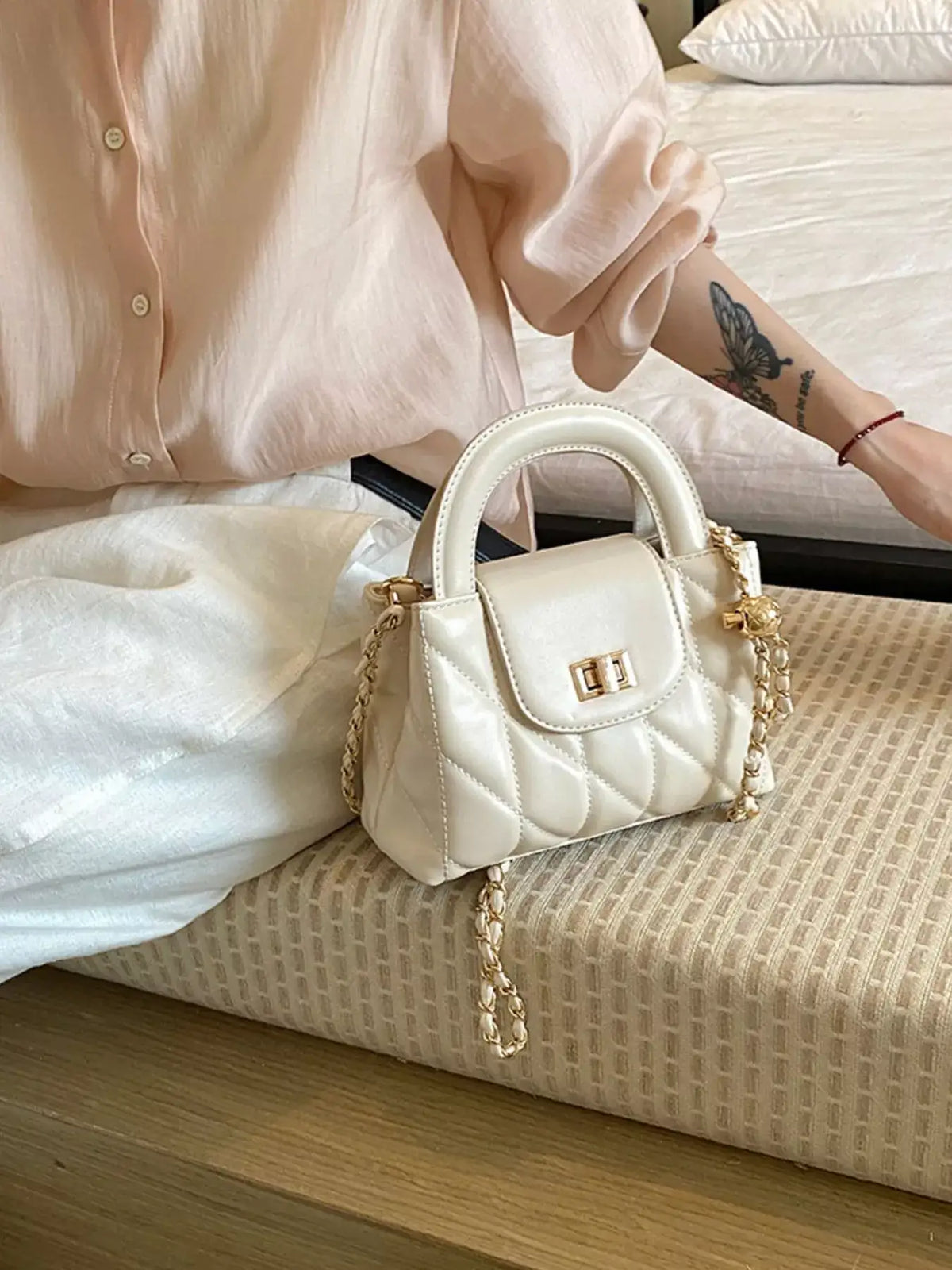 Cream quilted PU leather crossbody bag with gold chain strap and top handle by Evie's Dreamland.