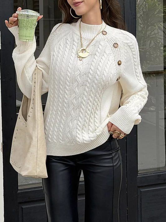 Woman wearing a white mock neck cable-knit sweater by Evie's Dreamland with black leather pants.