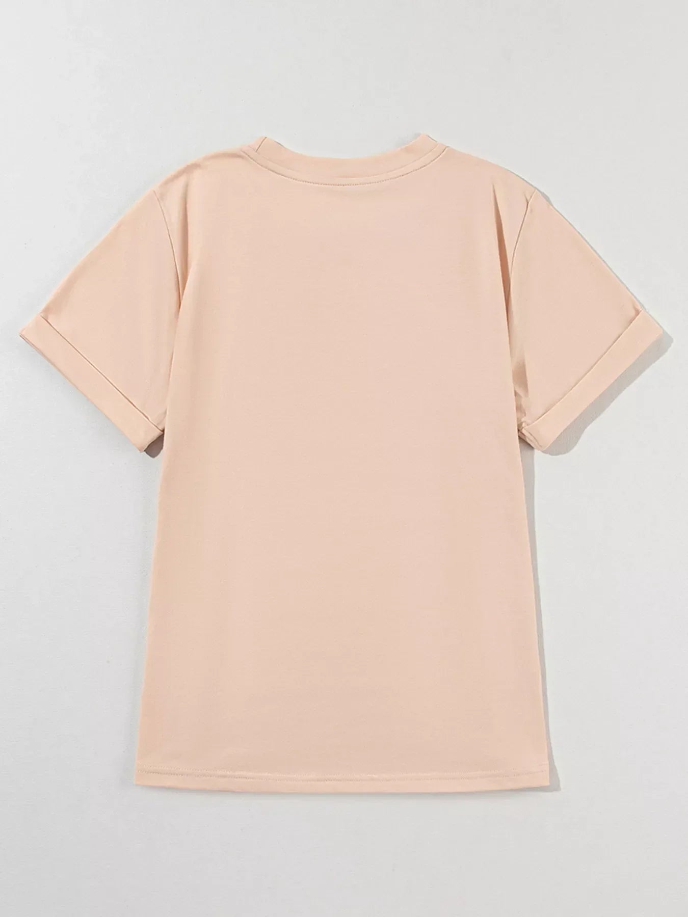 Back view of plain beige short sleeve T-shirt with rolled cuffs on light background