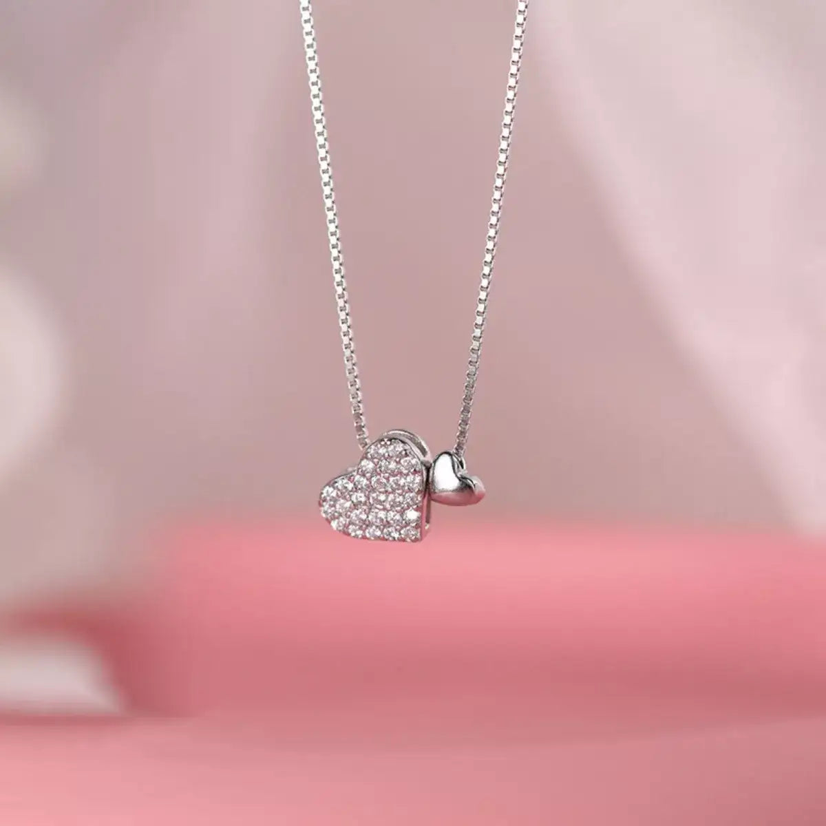 Evie's Dreamland 925 sterling silver necklace with two interlocking zircon-encrusted heart pendants.