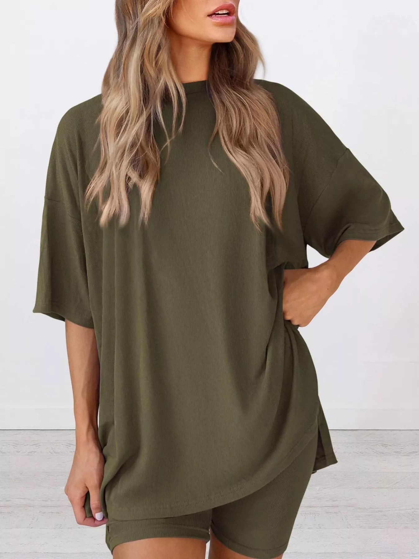 Woman wearing oversized olive green loungewear set with matching top and shorts