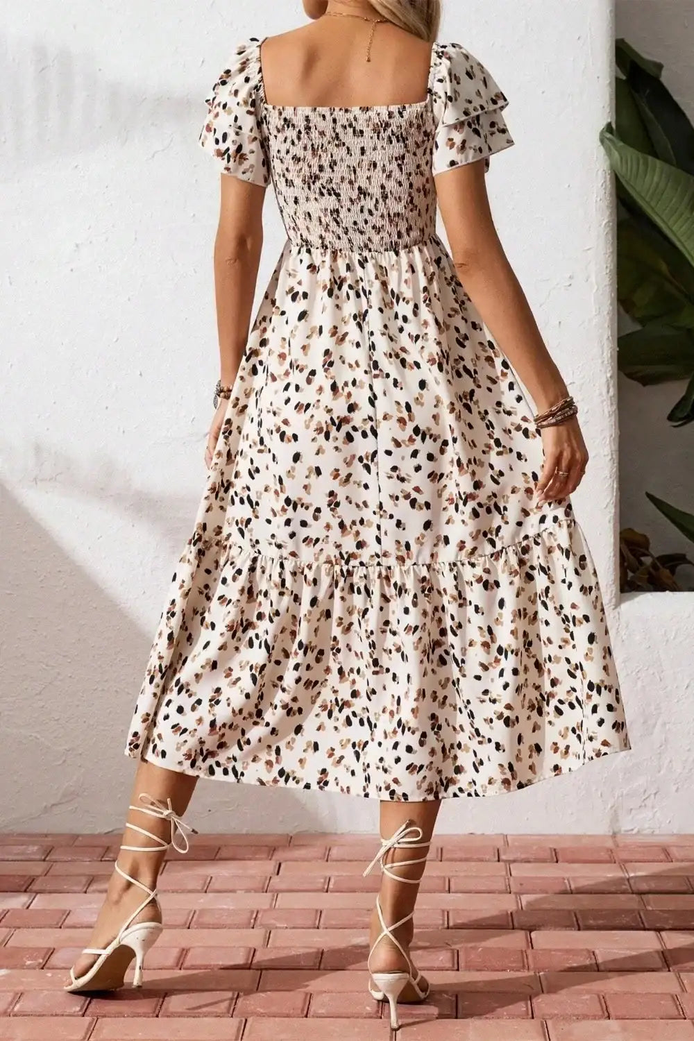 Floral midi dress with puff sleeves and tiered skirt, paired with white strappy heels