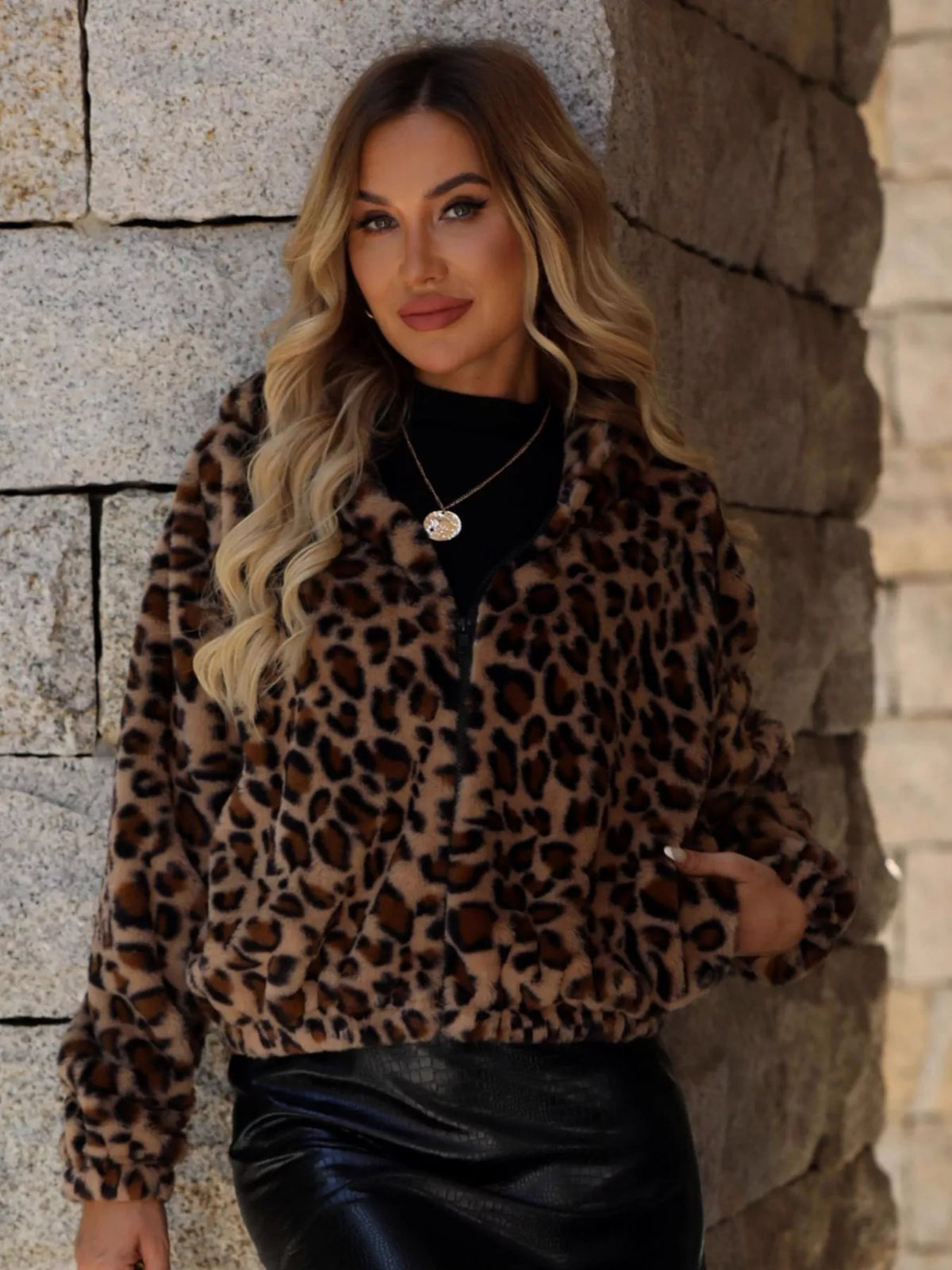 Woman wearing a brown leopard print zip-up hooded jacket by Evie's Dreamland and a black leather skirt.