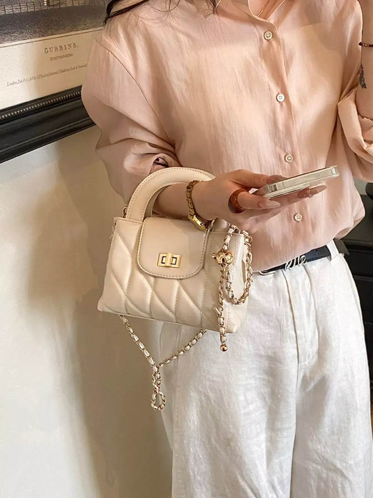 Evie's Dreamland quilted cream PU leather handbag with gold chain strap and handle.